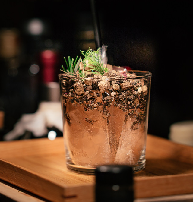 Ein Cocktail steht auf einem Holzbrett